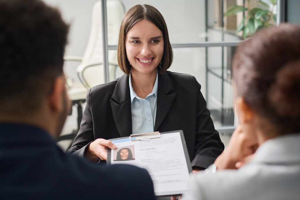 A job applicant passing her resume for a sales interview.